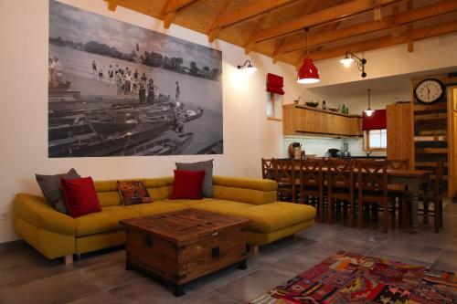a living room with a yellow couch and a kitchen at Döme's Point in Leányfalu