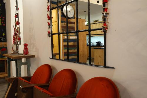 a mirror on a wall with orange chairs in a room at Döme's Point in Leányfalu