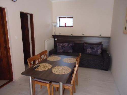 a dining room with a table and chairs and a couch at Partapartman in Gyula
