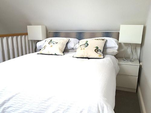 a bedroom with a white bed with two lamps at Pine Tree Lodge, Bridgnorth in Bridgnorth