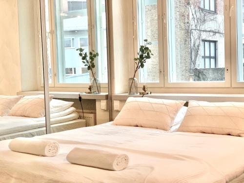 two beds in a room with two windows at City Home Finland Ratina - Spacious Studio with Own SAUNA and Great Location Next to Uros Live Arena in Tampere