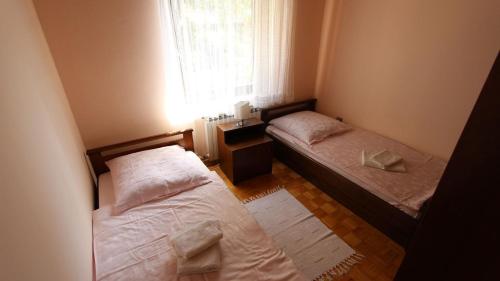 Dos camas en una habitación pequeña con ventana. en Apartment Prosinečki, en Malinska