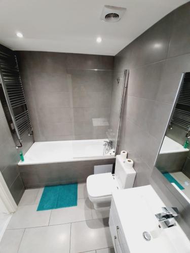uma casa de banho com uma banheira, um WC e um lavatório. em Southend On Sea Apartments - Close too Shops em Southend-on-Sea