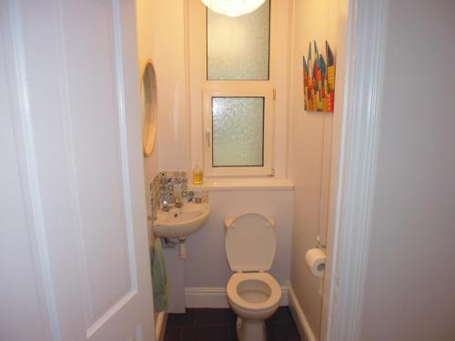 a small bathroom with a toilet and a sink at Stunning townhouse at Plymouth Hoe in Plymouth