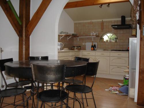 une cuisine avec une table et des chaises dans une pièce dans l'établissement Cornucopia Cottage, à Ingen