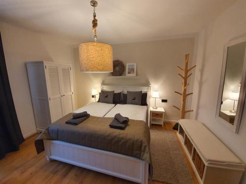 a bedroom with a large bed and a chandelier at Pension Reinhardshäusle in Reinhardshausen