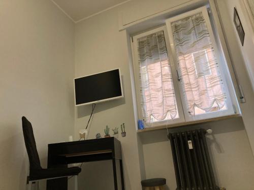 a room with a television and a desk and a window at Family in Potenza