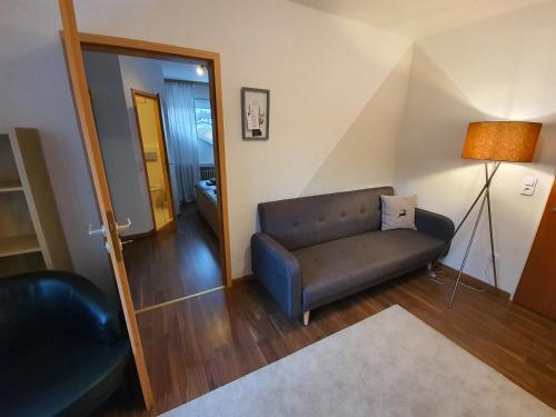 a living room with a couch and a lamp at Pension Reinhardshäusle in Reinhardshausen