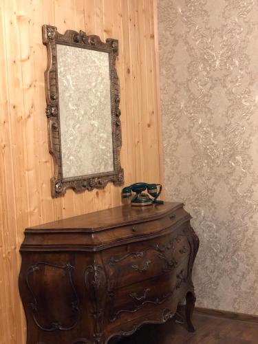 a mirror on a wall next to a wooden dresser at Mountain Residence in Tukhlya