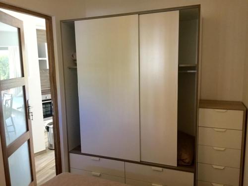 d'une grande armoire blanche dans le salon. dans l'établissement Appartement rénové aux portes de St tropez, à Gassin