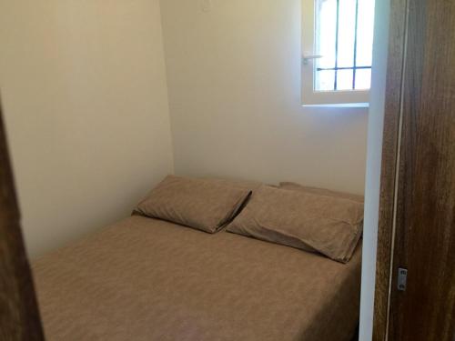 - un petit lit dans une petite chambre avec fenêtre dans l'établissement Appartement rénové aux portes de St tropez, à Gassin