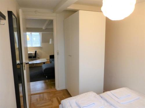 a small room with a bed and a mirror at Cozy apartment in vibrant Nørrebro in Copenhagen