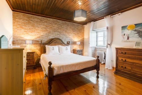 a bedroom with a bed and a brick wall at Casa Mont'Santo in Monsanto