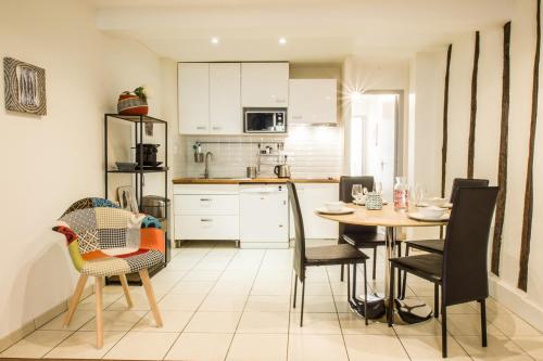 une cuisine et une salle à manger avec une table et des chaises dans l'établissement Le Montoulieu - proche Place des Carmes, à Toulouse