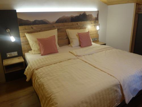 a bedroom with a large bed with red and white pillows at Doblerhof in Höslwang