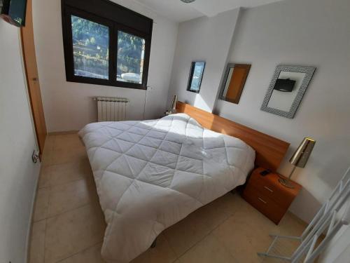 a bedroom with a large white bed and a window at Altissim Tarter - Inclès - Ransol in El Tarter
