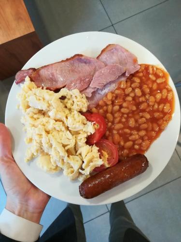a plate of food with eggs ham and beans at Britannia Study Hotel in Brighton & Hove