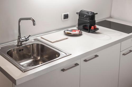 a kitchen counter with a sink and a appliance at Stay COOPER l Goethe Guesthouse in Bolzano