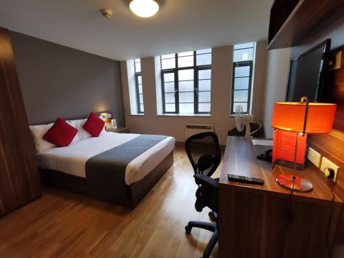 a hotel room with a bed and a desk and a desk at Britannia Study Hotel in Brighton & Hove