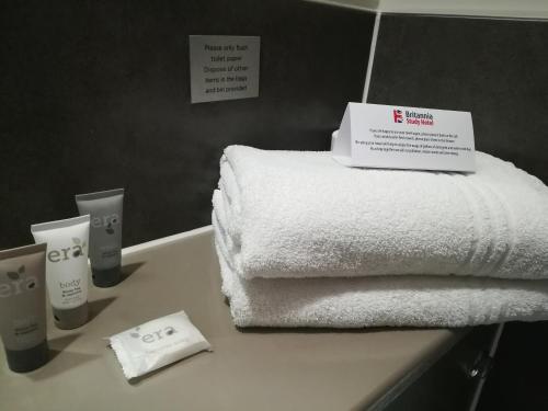 una pila de toallas en una encimera en el baño en Britannia Study Hotel, en Brighton & Hove