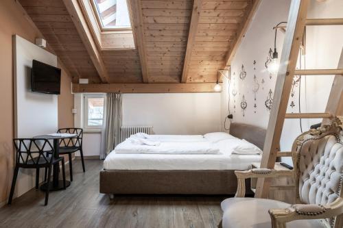 a bedroom with a bed and a table in a room at Stay COOPER l Goethe Guesthouse in Bolzano
