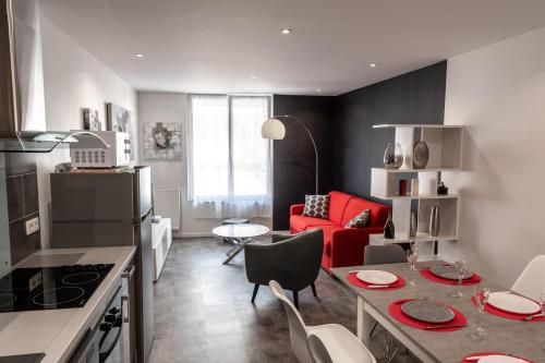 Il comprend une cuisine et un salon avec un canapé rouge. dans l'établissement Champenois GARAGE PRIVATIF hypercentre 6 pers, à Épernay