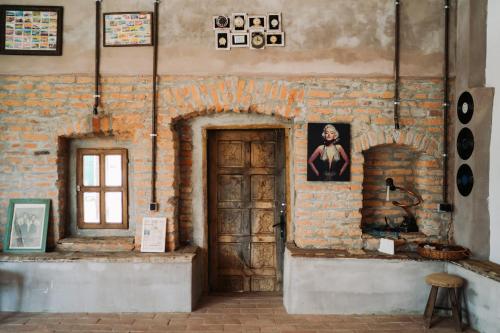 Cette chambre est dotée d'une porte en bois et d'un mur en briques. dans l'établissement Sura din Joseni, à Porumbacu de Sus