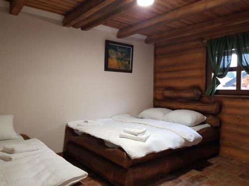 a bedroom with two beds with white sheets and a window at Apartman Trebević Dolina mira in Pale