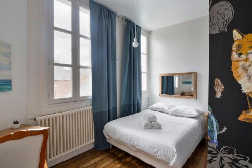 Habitación pequeña con cama y ventana en Les Trois Rois - Duplex Familial de Charme en cœur de ville en Rennes