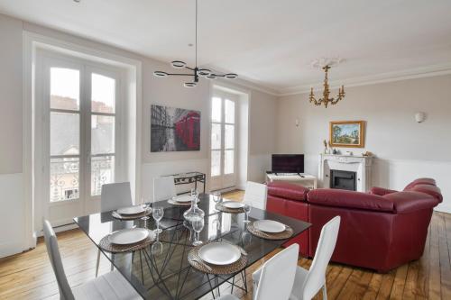 sala de estar con mesa y sofá rojo en Les Trois Rois - Duplex Familial de Charme en cœur de ville en Rennes