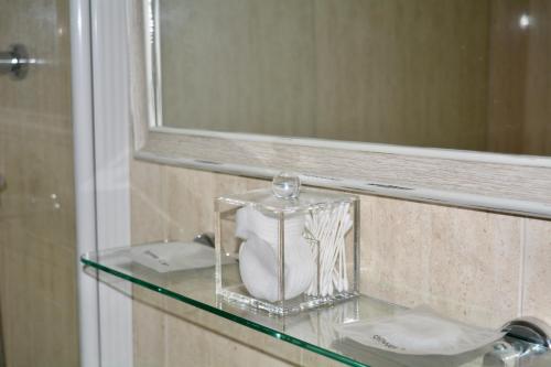 a glass shelf in a bathroom with a mirror at Queens Gardens - Kato Paphos - next to Kings Ave Mall --- by Yiota in Paphos