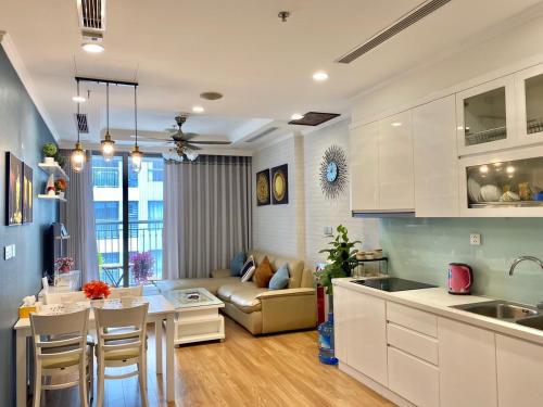 kuchnia i salon z kanapą i stołem w obiekcie Vinhomes Time City and Parkhill Premium Apartment w mieście Hanoi