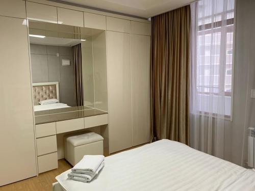 um quarto de hotel com uma cama e um espelho em Highvill AST em Astana