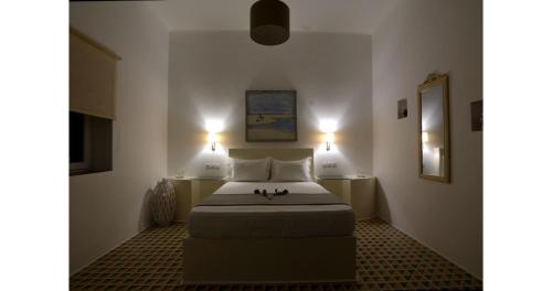 ein Schlafzimmer mit einem Bett mit zwei Lichtern an der Wand in der Unterkunft Pier's House Jacuzzi in Pollonia