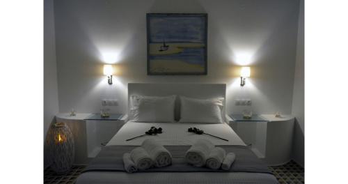 a bedroom with a white bed with two books on it at Pier's House Jacuzzi in Pollonia