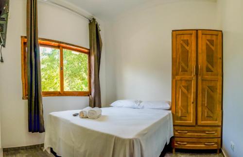 
a bedroom with a bed and a dresser at Residencia Vitória Mar in Ubatuba
