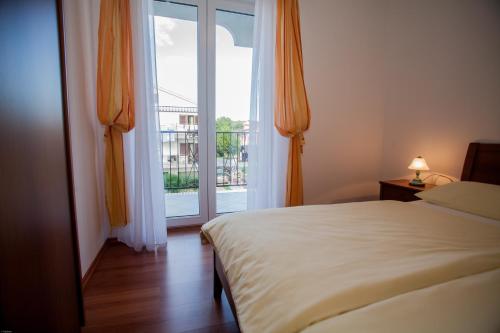 a bedroom with a bed and a sliding glass door at Apartments Bogović in Malinska