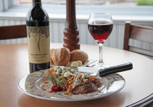 une assiette de nourriture et un verre de vin sur une table dans l'établissement Lake Front Hotel, à Cooperstown