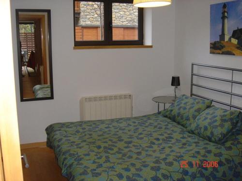 a bedroom with a bed and a table and windows at Valencia de Aneu TP in Valencia de Aneu