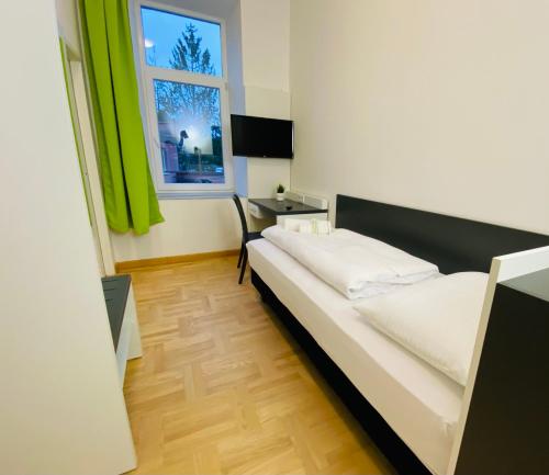 a bedroom with a bed and a desk and a window at bestprice Hotel Aachen Hauptbahnhof in Aachen