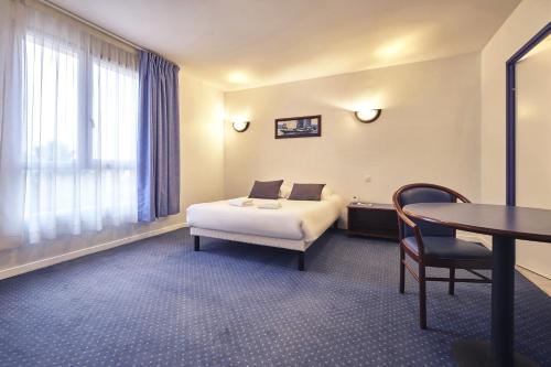 a hotel room with a bed and a table at Comfort Aparthotel Carcassonne in Carcassonne