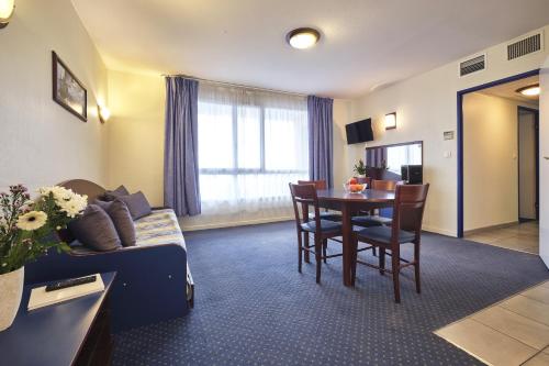 a living room with a couch and a table at Comfort Aparthotel Carcassonne in Carcassonne