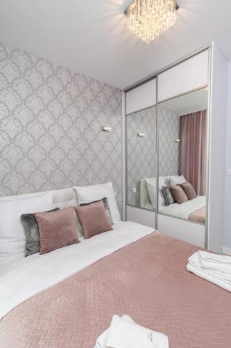 a bedroom with two beds and a large mirror at Angel Apartments 2 in Krakow