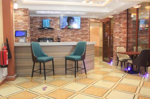 a bar in a restaurant with chairs and a counter at Vickmark Hotel in Nakuru