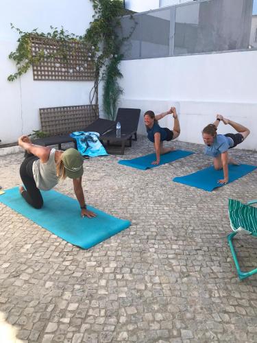 a group of people doing yoga in a courtyard at GetWet Surfcamp in Costa da Caparica