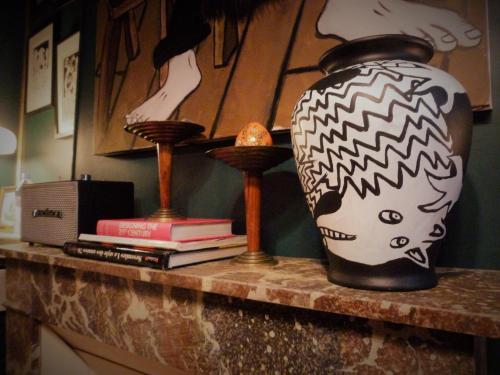 eine Vase auf einer Theke mit Büchern in der Unterkunft La Galerie-gîte in Metz