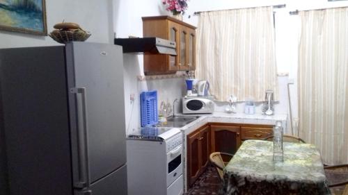 a small kitchen with a refrigerator and a table at 2 bedrooms appartement at Pointe aux piments 200 m away from the beach with shared pool balcony and wifi in Pointe aux Piments