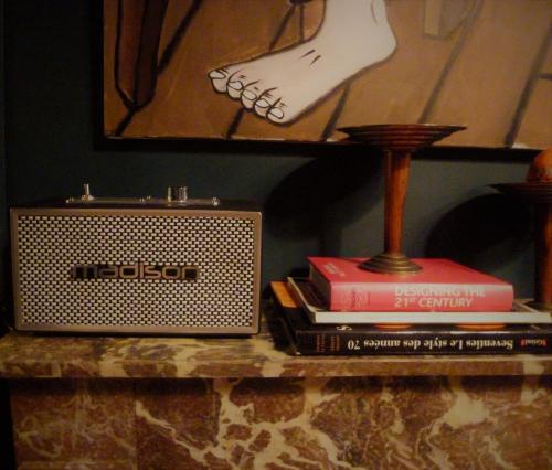 une table avec une radio et des livres sur elle dans l'établissement La Galerie-gîte, à Metz