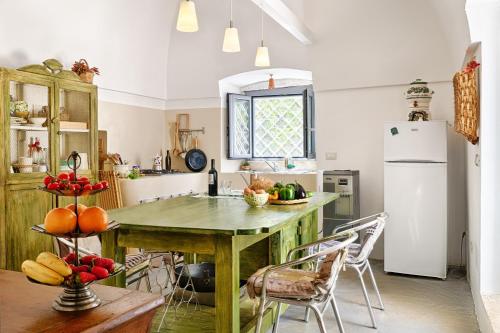 cocina con mesa de madera con sillas y nevera en One bedroom house with private pool and furnished garden at Ceglie Messapica, en Ceglie Messapica