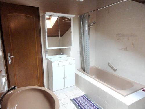 a bathroom with a tub and a sink and a toilet at Maison de charme à Saint-Laurent-la-Roche avec jardin clôturé in Saint-Laurent-la-Roche